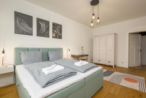 een slaapkamer met een bed met een blauw hoofdeinde bij Arbio I Modern Apart near Leipzig Stötteritz in Leipzig