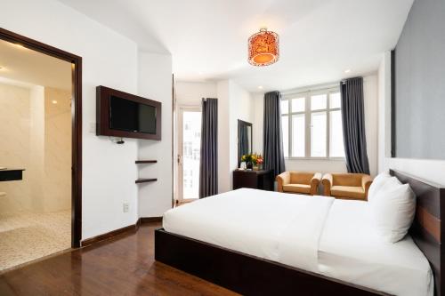 Habitación de hotel con cama blanca y espejo en A&A Toronto Hotel, en Ho Chi Minh