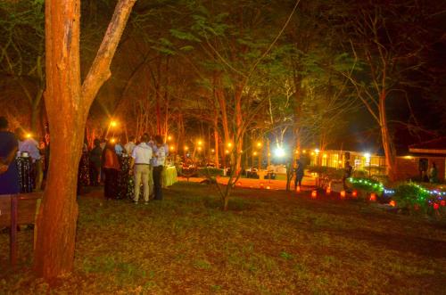 a group of people standing in a park at night at Sagana Getaway Resort in Maranjua