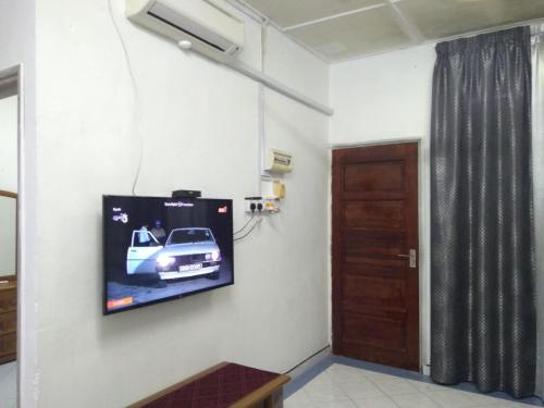 a flat screen tv hanging on a wall in a room at Rumah Tamu AZ Pasir Tumboh in Kampong Binjai
