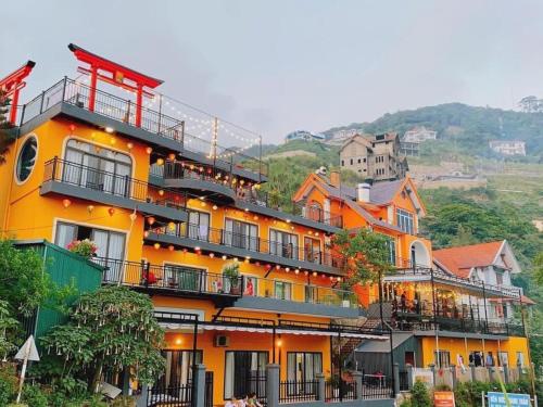 a large orange building with balconies on a hill at Sunset Villa Tam Dao - Venuestay in Vĩnh Phúc