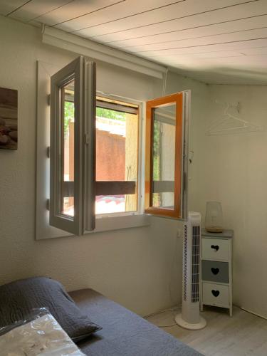a bedroom with two windows and a bed in it at Mazet de vacances residence l espai in Saint-Martin-de-Brômes