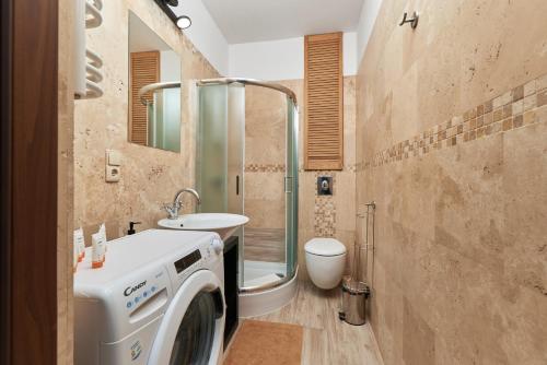 a bathroom with a washing machine and a toilet at Rynek Apartment The Heart of the City by Renters in Wrocław