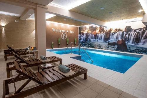a hotel lobby with a pool and a waterfall mural at STUDIO APARTMAN BAROSSA in Vinkovci