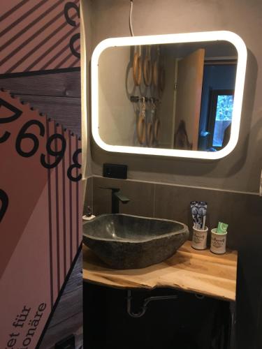 a bathroom with a stone sink in a trailer at Bike 'n' Board Lodge Brandnertal in Brand