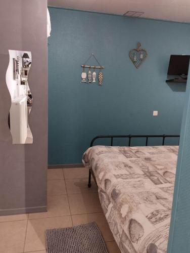 a bedroom with a bed and a blue wall at La chambre d Angeline in Foy-Notre-Dame