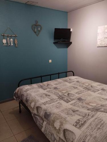a bedroom with a bed and a tv on the wall at La chambre d Angeline in Foy-Notre-Dame