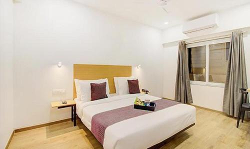 a bedroom with a large bed and a window at FabHotel Ashray Residency in Navi Mumbai