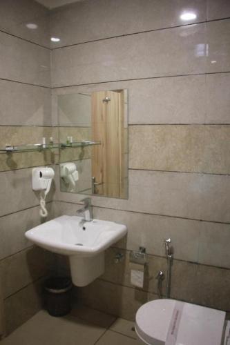 a bathroom with a sink and a toilet at Hotel Reva Regency in Bhopal