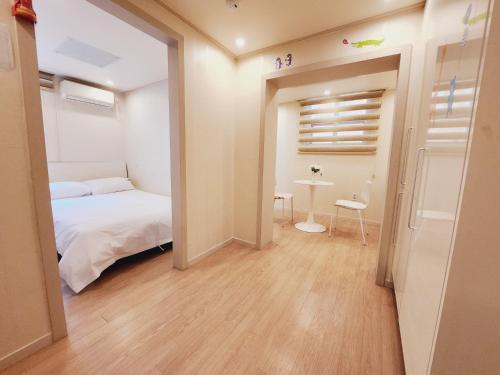 a small bedroom with a bed and a table at Olive hostel R(Residence) in Seoul