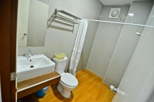 a bathroom with a sink and a toilet and a shower at Sabuy Best Hotel Phayao in Phayao