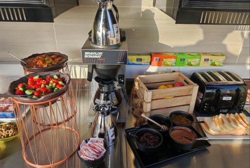 a kitchen counter with a coffee maker and some food at Hotel Pjazza Merkanti - Boutique Living in Valletta