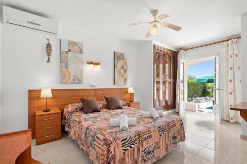 a bedroom with a large bed and a balcony at Villa Piscis in Son Bou