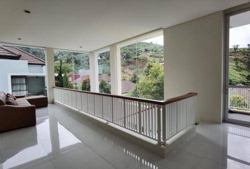 a living room with white walls and large windows at Platinum Yellow Bandung Villa 24 Pax Private Pool in Bengkok