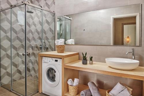 een badkamer met een wasmachine en een wastafel bij Villa Danae Zante in Zakynthos