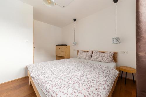 a bedroom with a bed in a room with white walls at Hiša na soncu / Sun house in Zgornje Gorje