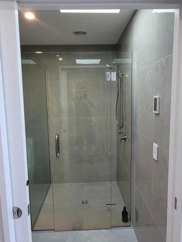 a shower with a glass door in a bathroom at Taimana Boutique Motel in Diamond Harbour