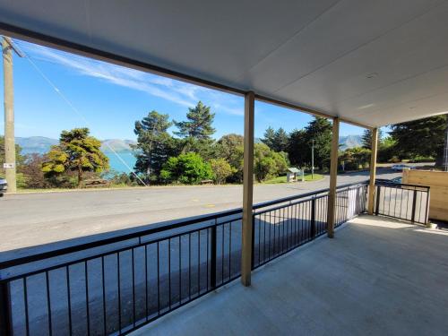 a balcony with a view of a street and trees at Taimana Boutique Motel in Diamond Harbour