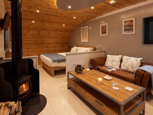 een woonkamer met een houtkachel en een bank bij Middle Longlands in Cartmel