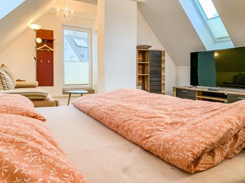 a bedroom with a bed and a flat screen tv at Ferienwohnungen und Ferienhäuser Gohr in Stralsund