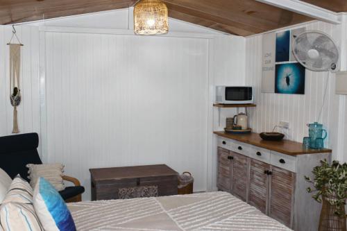 a bedroom with a bed and a desk with a microwave at The Bunkhouse in Exmouth