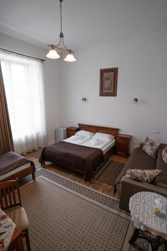 a bedroom with two beds and a couch at Pensiunea Gasthaus Alte Post in Sighişoara