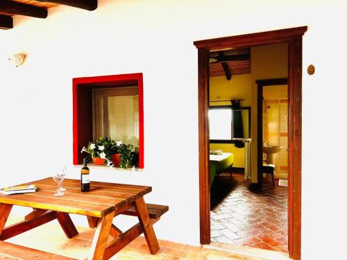 een kamer met een tafel en een fles wijn bij Agriturismo Conca' e Janas in Dorgali