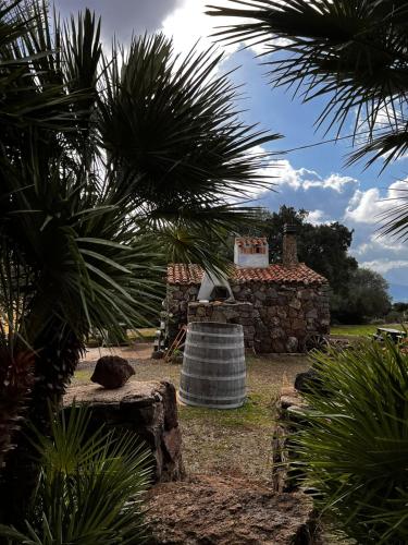 a stone house with a large bell in front of it at Agriturismo Conca' e Janas in Dorgali