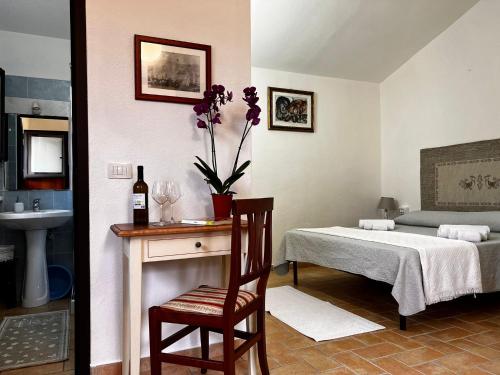 a bedroom with a bed and a table and a chair at Agriturismo Conca' e Janas in Dorgali