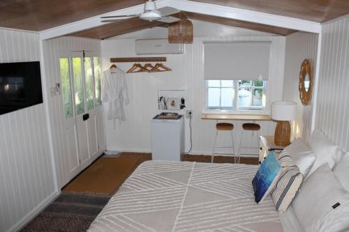 a bedroom with a bed and a kitchen with a window at The Bunkhouse in Exmouth
