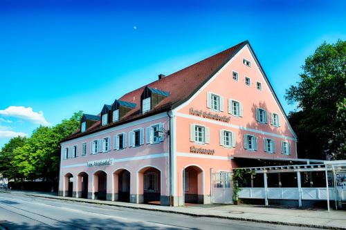 um grande edifício laranja e branco ao lado de uma rua em ACHAT Hotel SchreiberHof Aschheim em Aschheim
