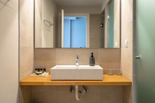 a bathroom with a white sink and a mirror at Joy Breeze in Kefallonia