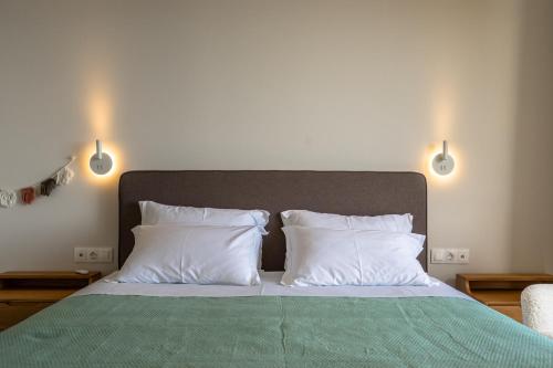a bed with white pillows and a green blanket at Joy Breeze in Kefallonia