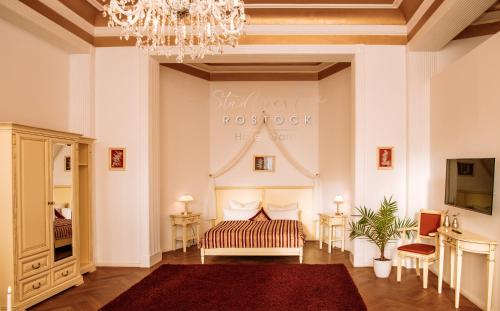 a living room with a bed and a chandelier at Stadtperle Rostock in Rostock