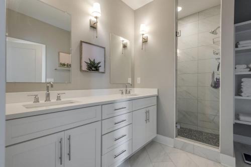 a white bathroom with two sinks and a shower at Classy, Cozy, Close to downtown in Nashville