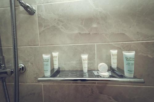 a shelf in a bathroom with four cups on it at KISIMANI ECO RESORT & SPA LTD in Isiolo