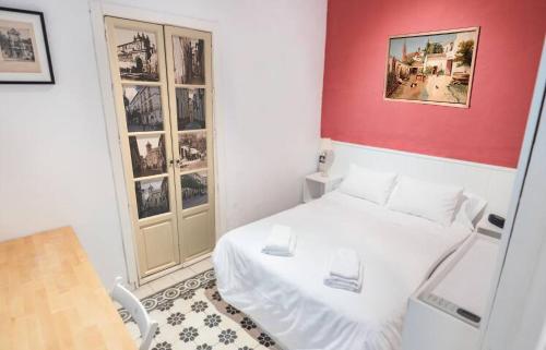 セビリアにあるHome in Seville V33-Bの白いベッドと赤い壁が備わる小さなベッドルーム1室が備わります。