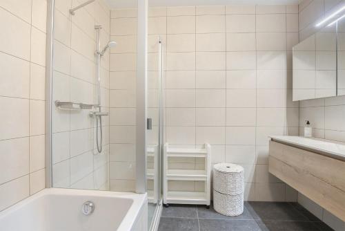 a bathroom with a shower and a tub and a sink at Hello Zeeland - Appartement Port Scaldis 03-071 in Breskens