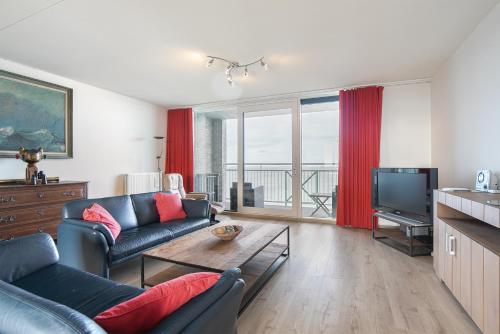a living room with a couch and a tv at Hello Zeeland - Appartement Port Scaldis 03-071 in Breskens