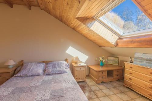 a attic bedroom with a bed and a skylight at Vacances à la montagne in Saint-Julien-en-Champsaur