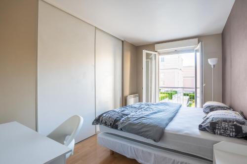 een witte slaapkamer met een bed en een raam bij La Nuit en Rose - 3 chambres - Balcon in LʼHay-les-Roses