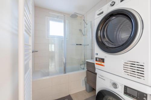 een wasmachine in een badkamer met een douche bij La Nuit en Rose - 3 chambres - Balcon in LʼHay-les-Roses