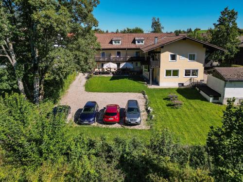 three cars parked in a driveway in front of a house at Pension Freiheit in Pfronten
