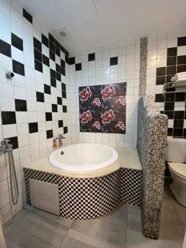 a bathroom with a bath tub and a toilet at Kenting Bayview Hotel in Nanwan