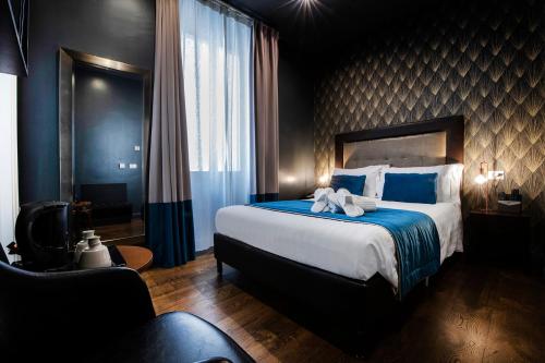a hotel room with a large bed and a chair at Hotel 87 eighty-seven - Maison d'Art Collection in Rome