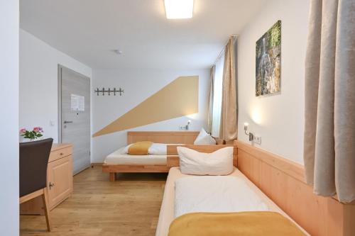 a hotel room with two beds and a tv at Pension Freiheit in Pfronten