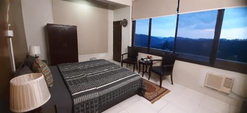a bedroom with a bed and a table and chairs at LEVEL FIVE ZERO in Murree