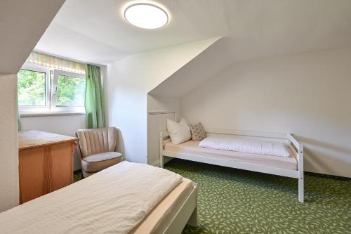 a room with two beds and a desk and a bed at Pension Freiheit in Pfronten