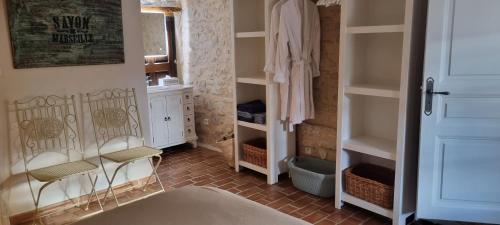 a walk in closet with two chairs in a room at Mas Tulipe de Soie in Bevons