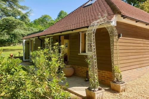 a small house with an archway in front of it at Little Vintners in Thakeham